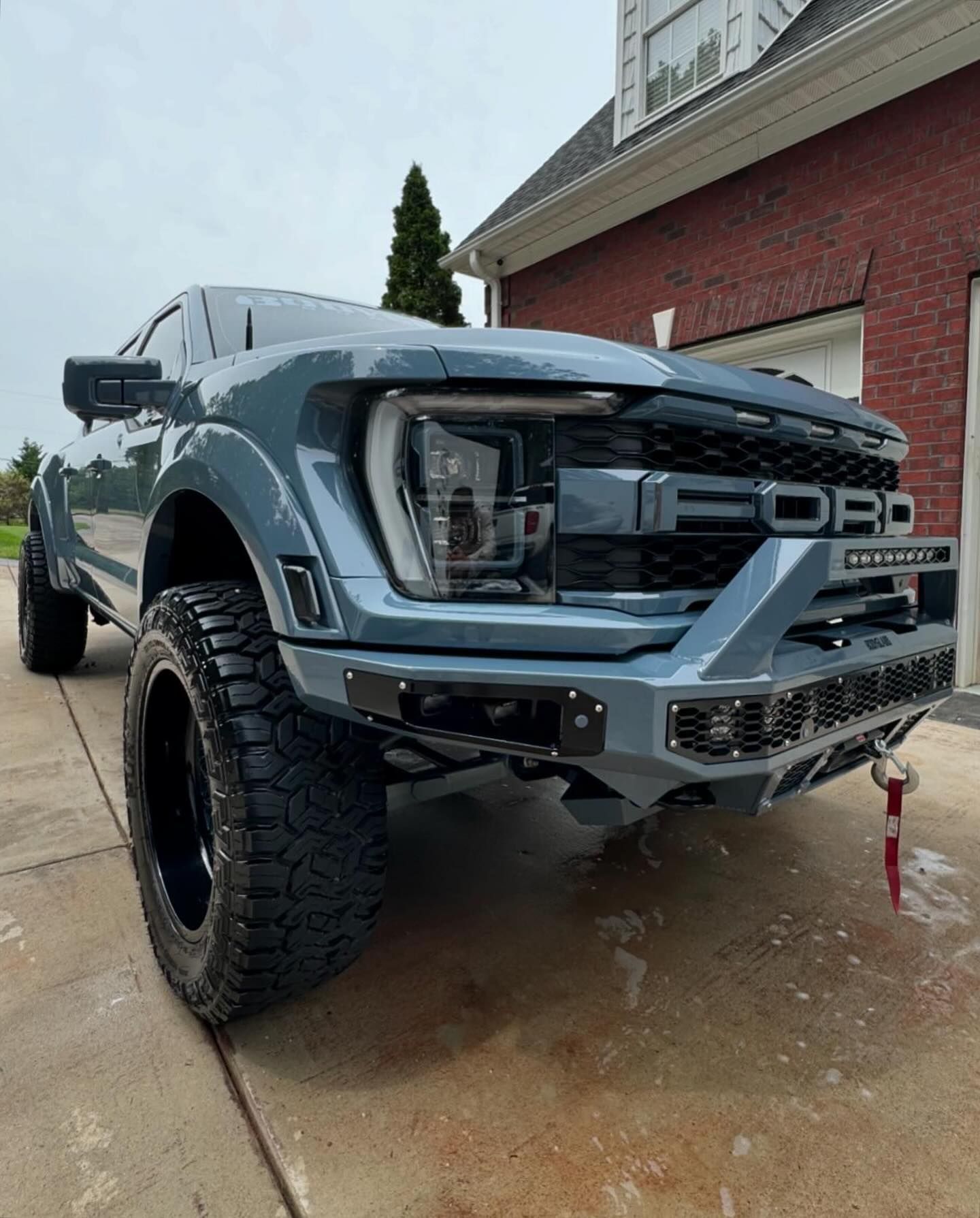 A ford raptor is parked in front of a brick building.