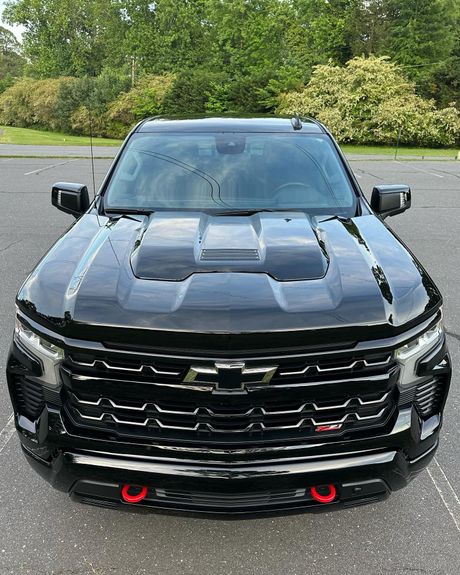 A black chevrolet truck is parked on the side of the road.