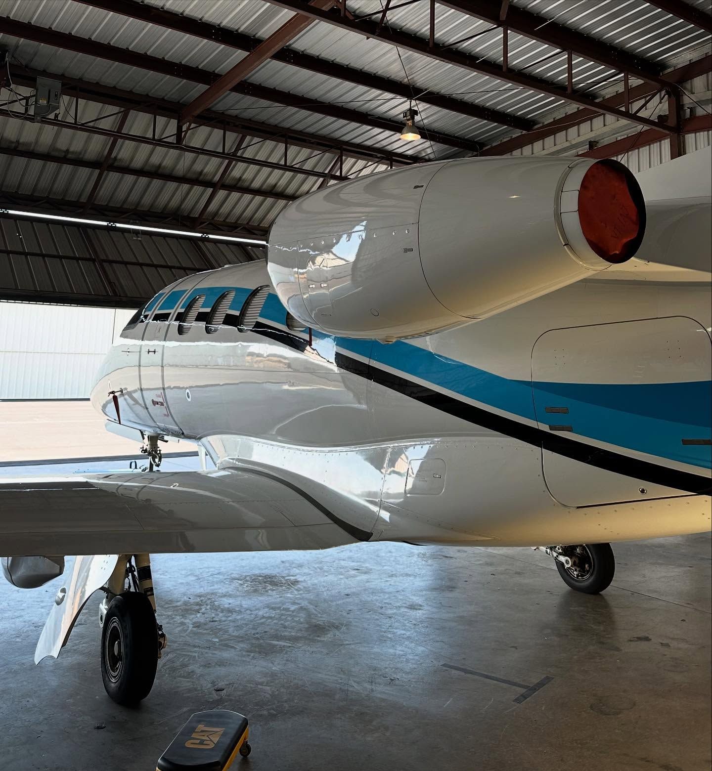 A blue and white airplane is parked in a hangar