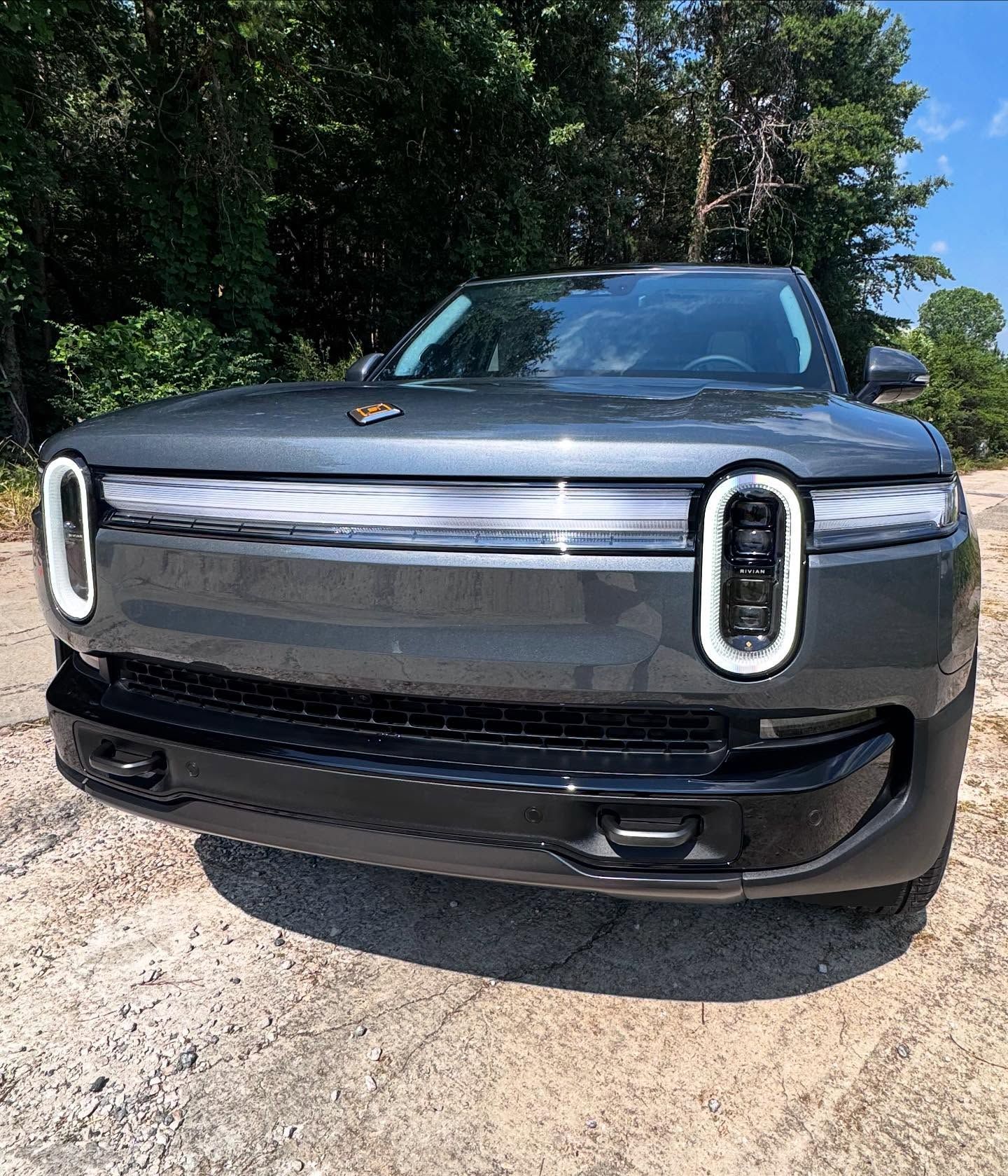 A gray car is parked on the side of the road.