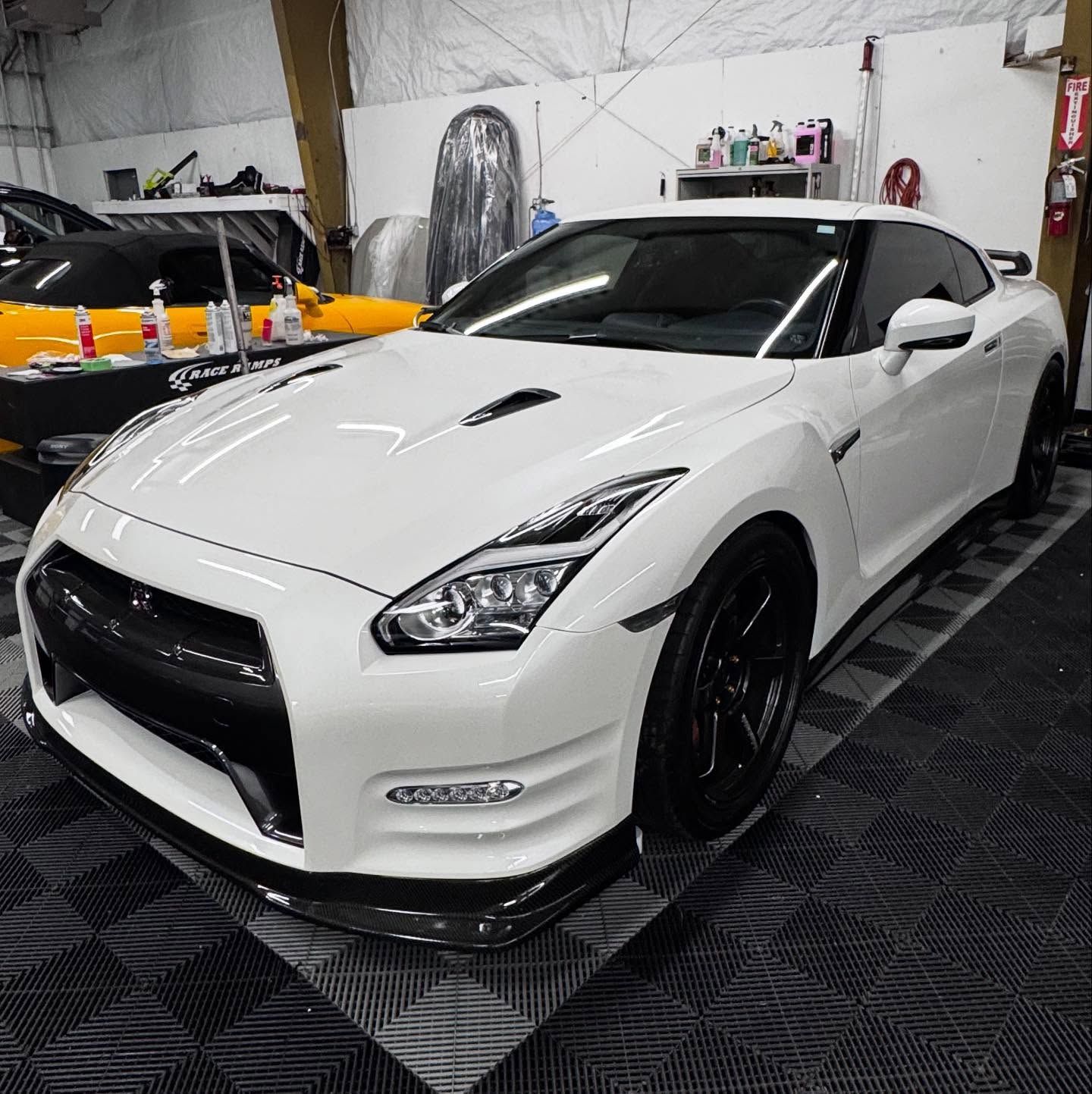 A white sports car is parked in a garage
