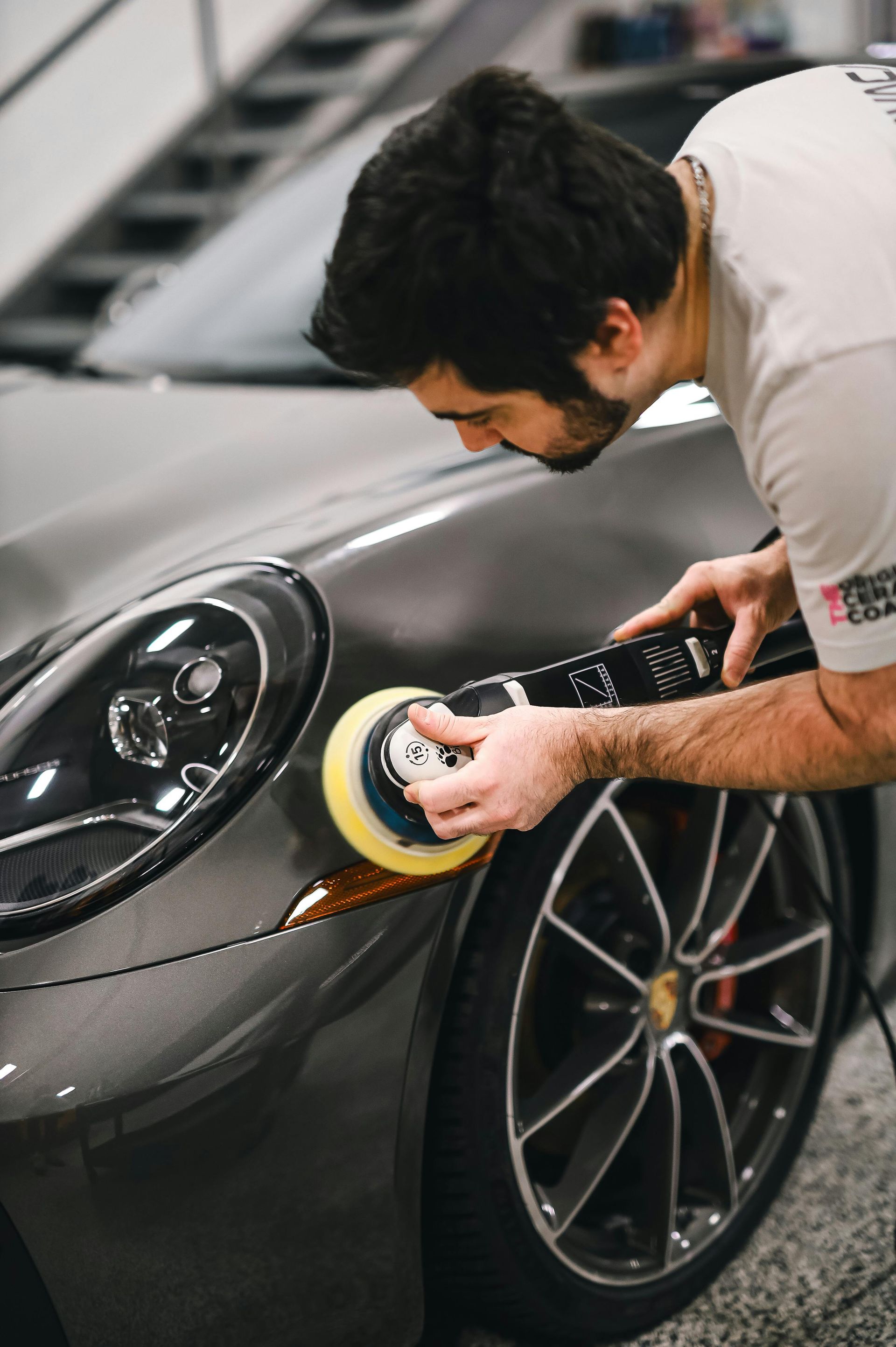 A man is polishing a car with a polisher.