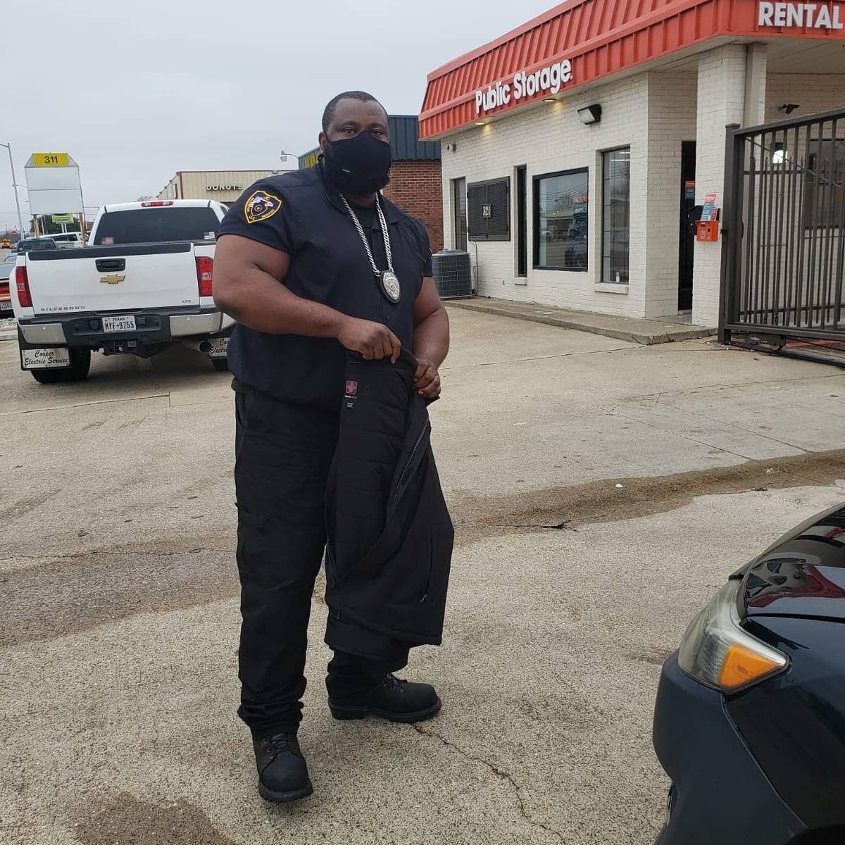 A man wearing a mask is standing in front of a building that says rental