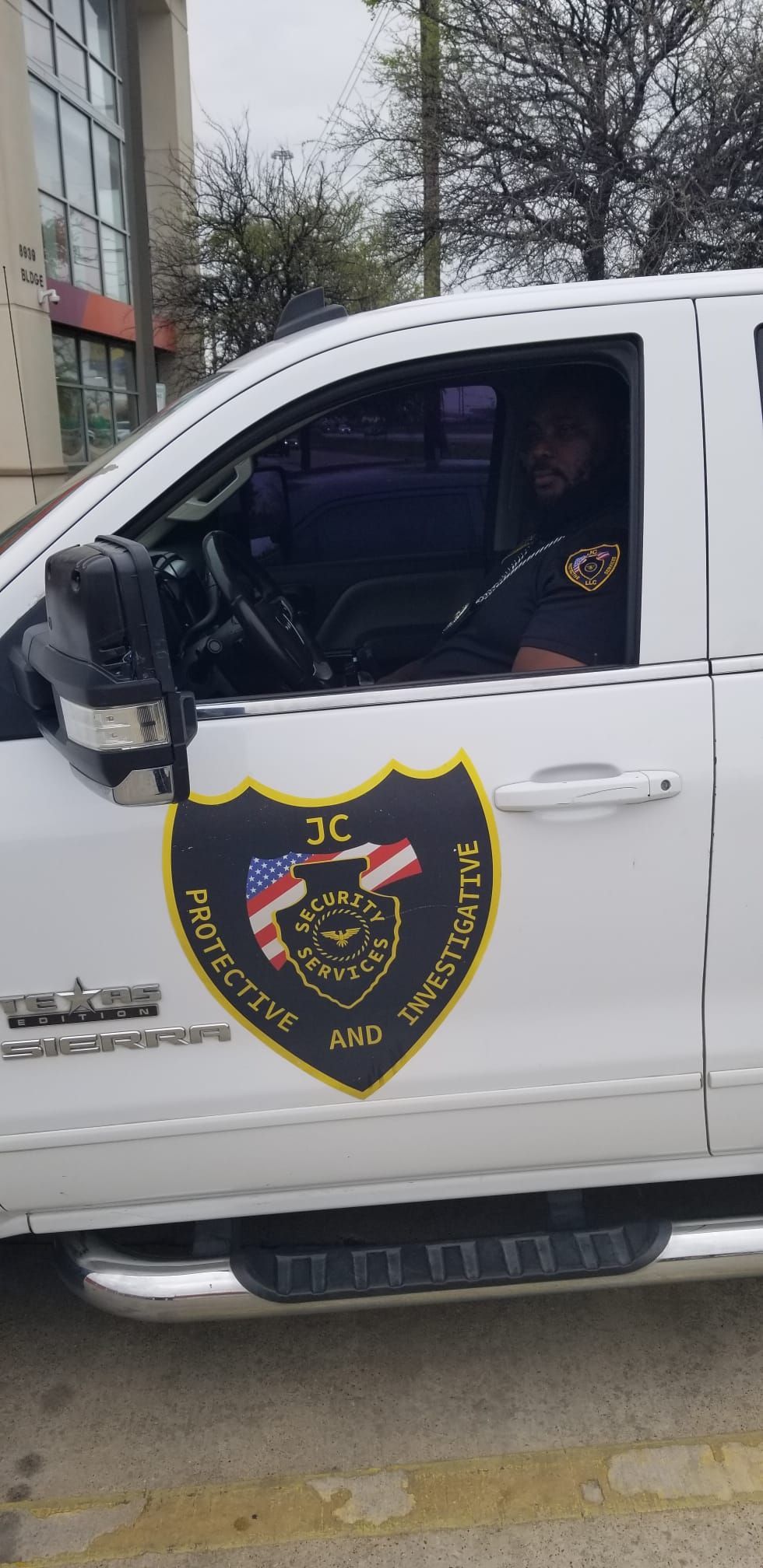 A man is sitting in the driver 's seat of a white truck.