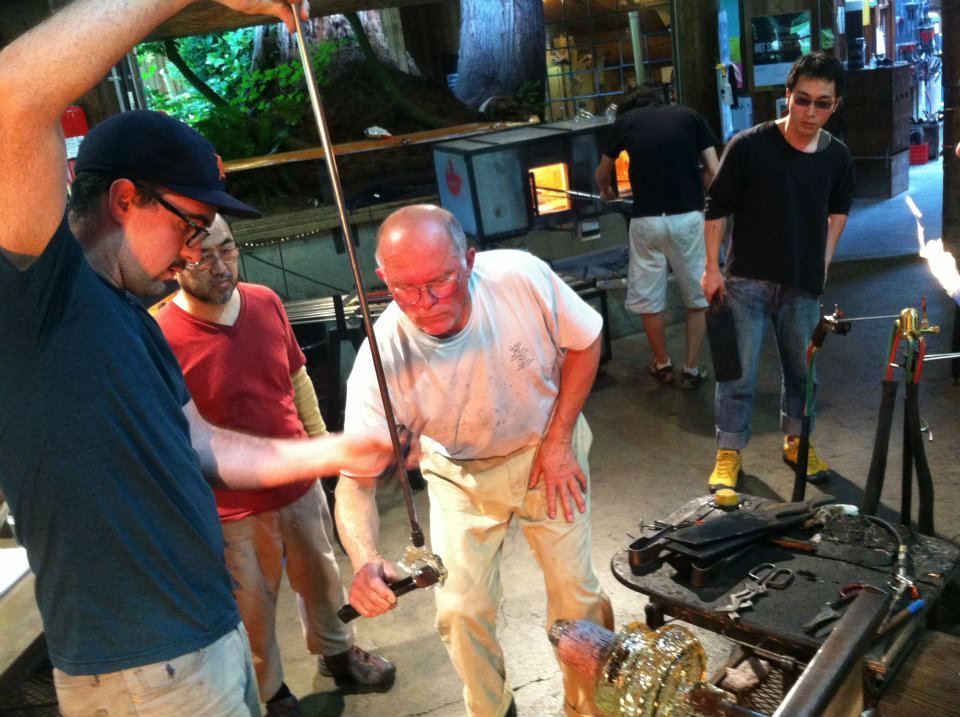 Glassblowing workshop: John de Wit, working with molten glass and tools near furnace.