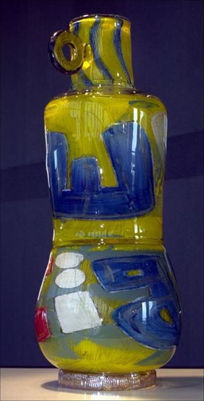 Glass sculpture, yellow and blue with abstract shapes.