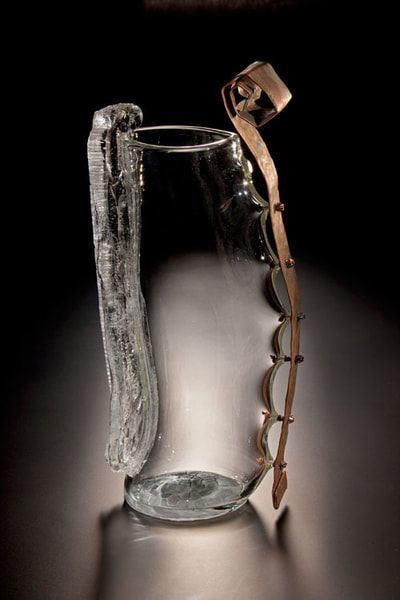 Glass and copper sculpture with a clear glass base and textured side, copper details.