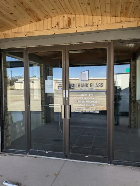 Exterior view of Oil Bank Glass building with glass doors, a sign and wood siding.
