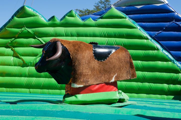 Mechanical bull game surrounded by inflatables
