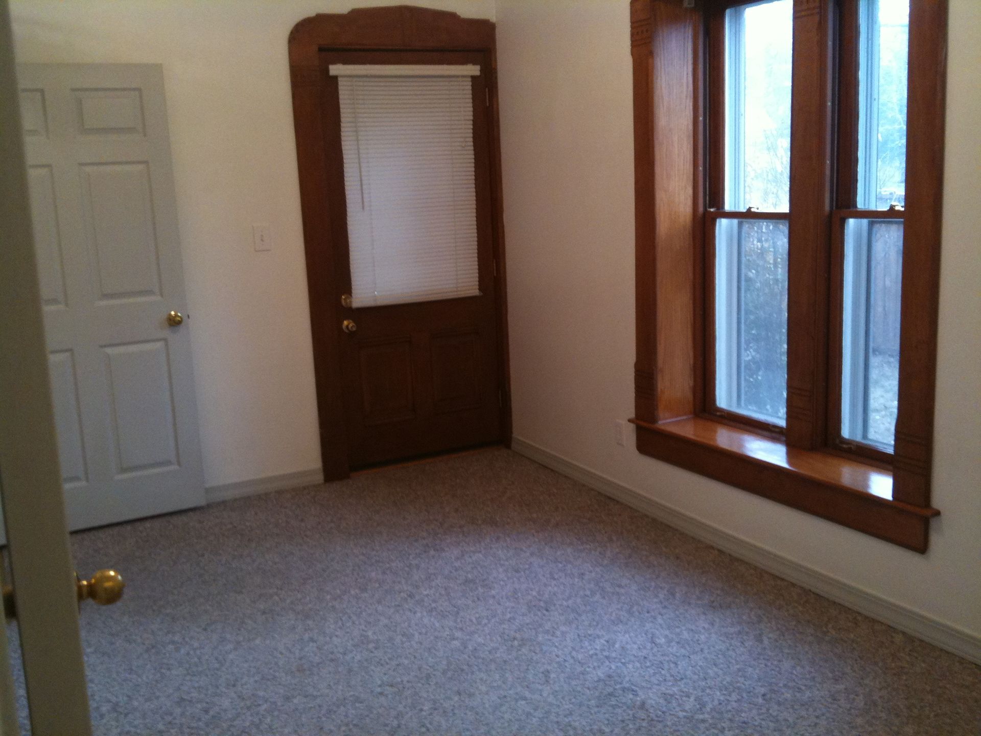 An empty room with two windows and a door