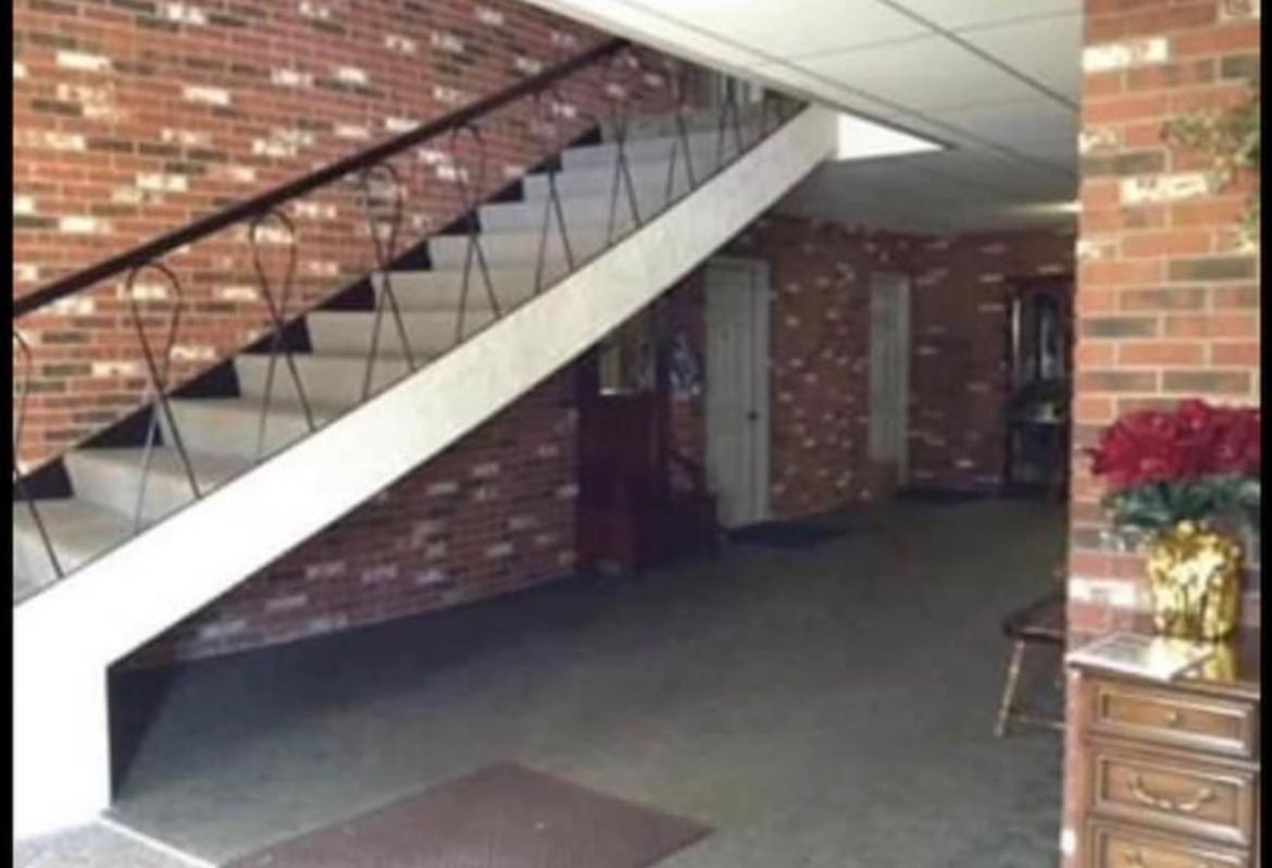 A staircase in a building with a brick wall