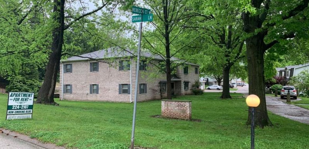 A house with a lot of grass and trees in front of it.