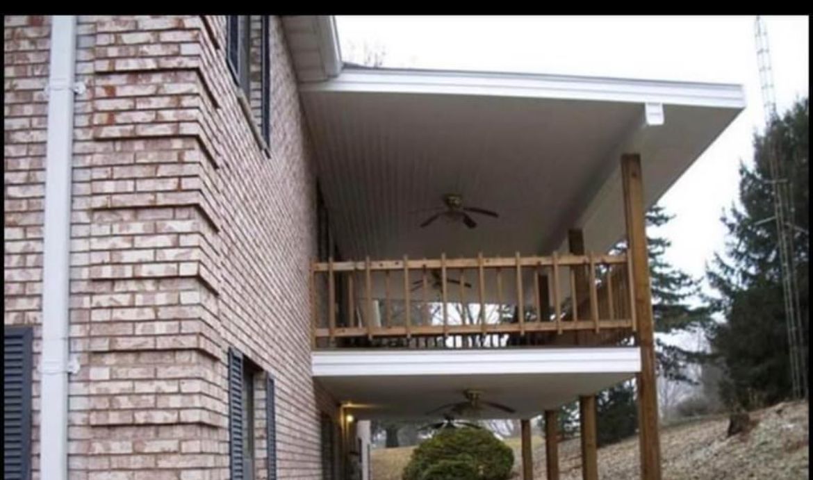 A brick house with a porch and a ceiling fan