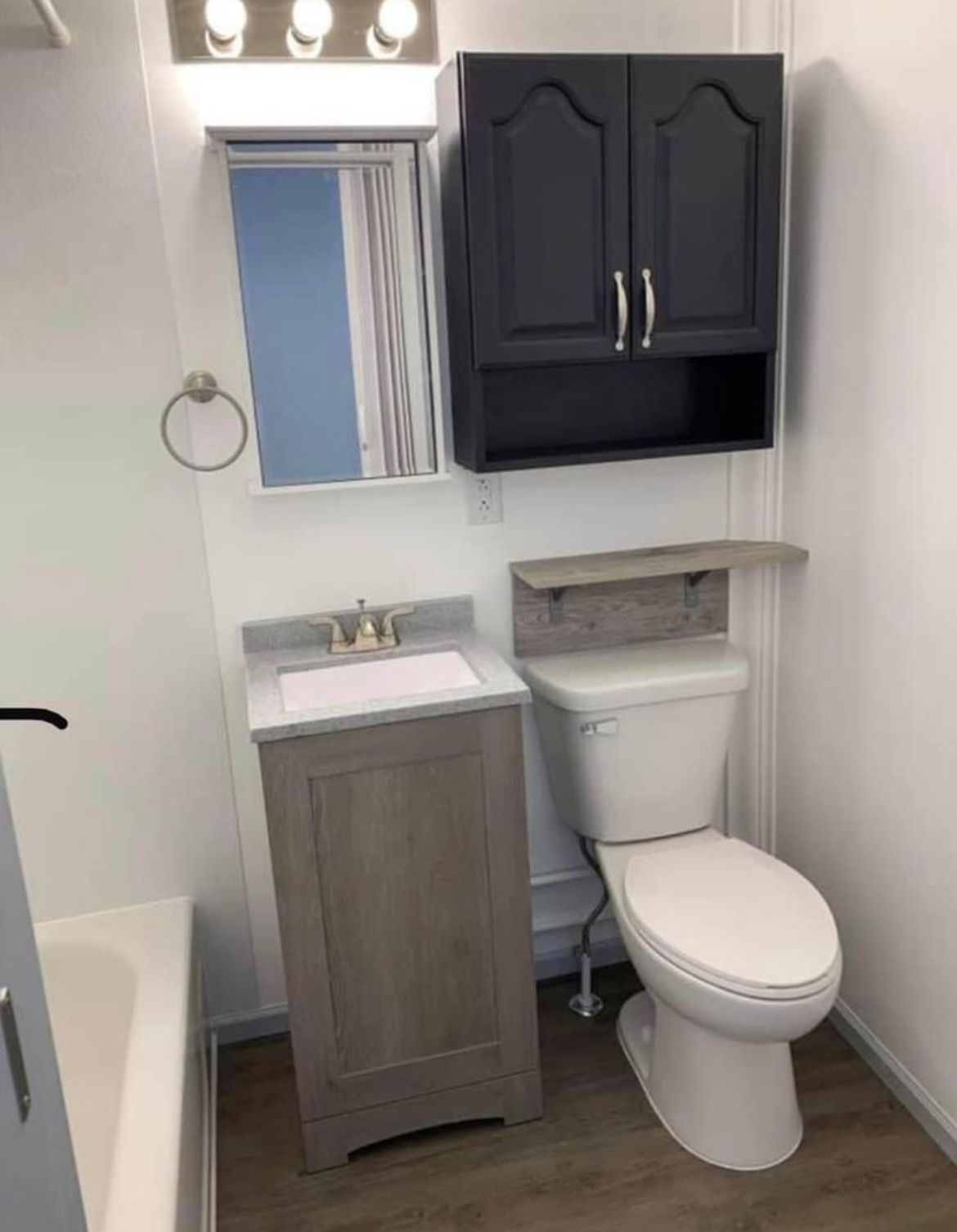A bathroom with a toilet , sink and mirror.