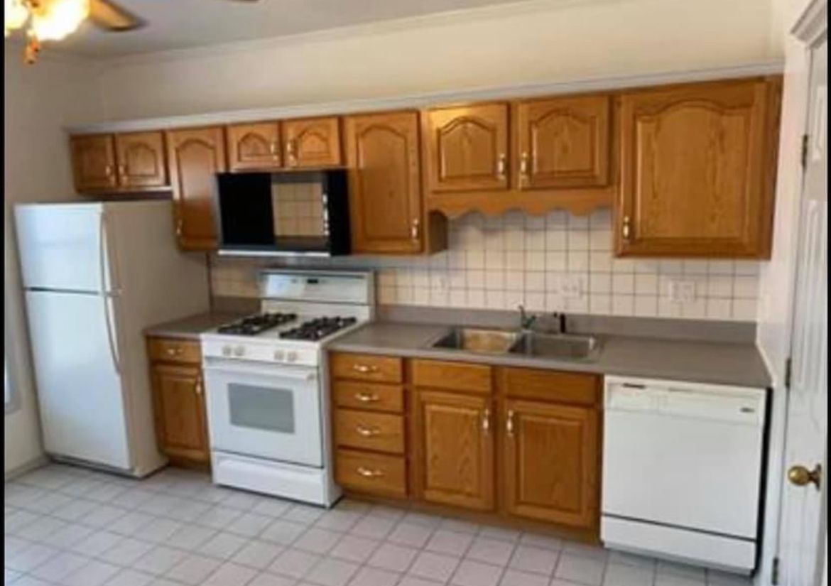 A kitchen with wooden cabinets and a white refrigerator