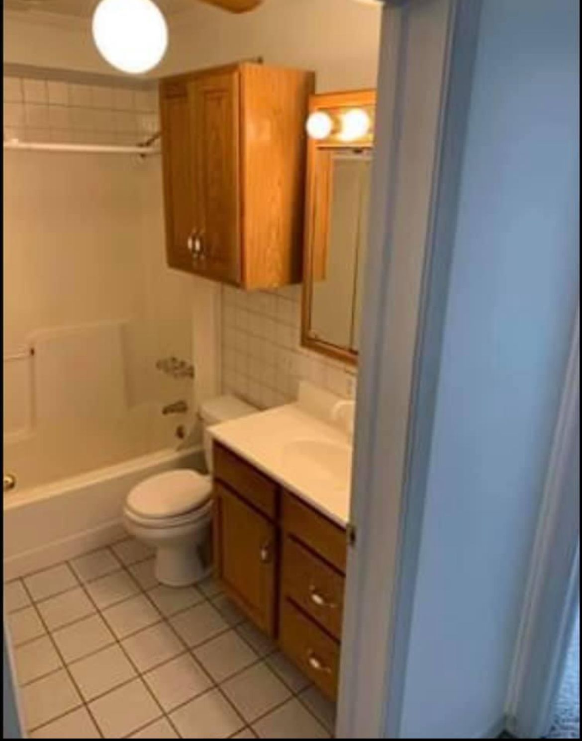 A bathroom with a toilet , sink , and bathtub.