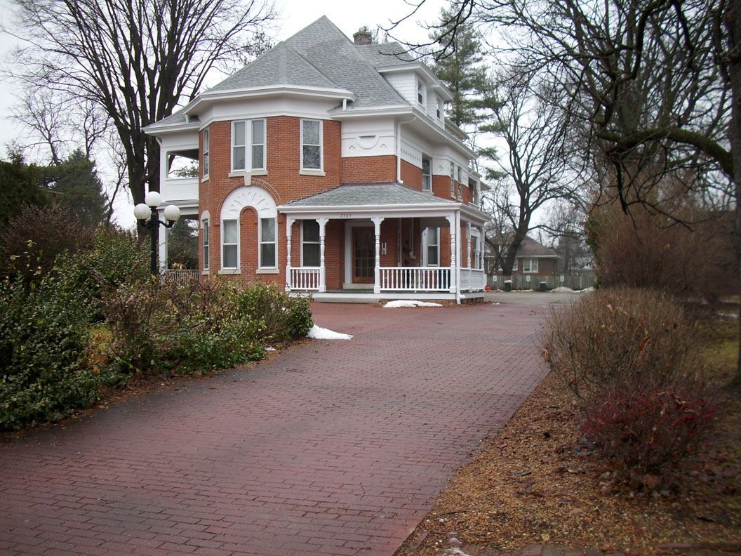 A large brick house with a driveway leading to it