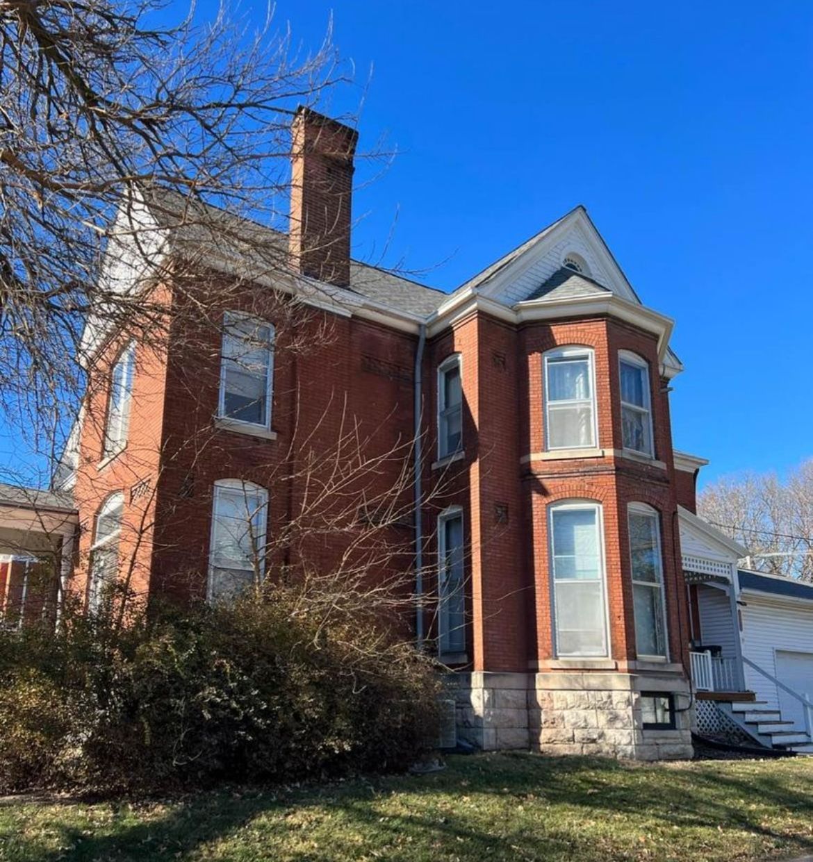 A large brick house with a blue sky in the background