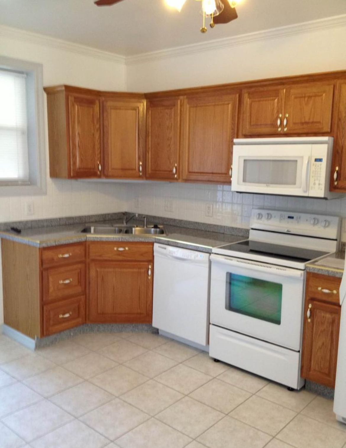 A kitchen with wooden cabinets and white appliances