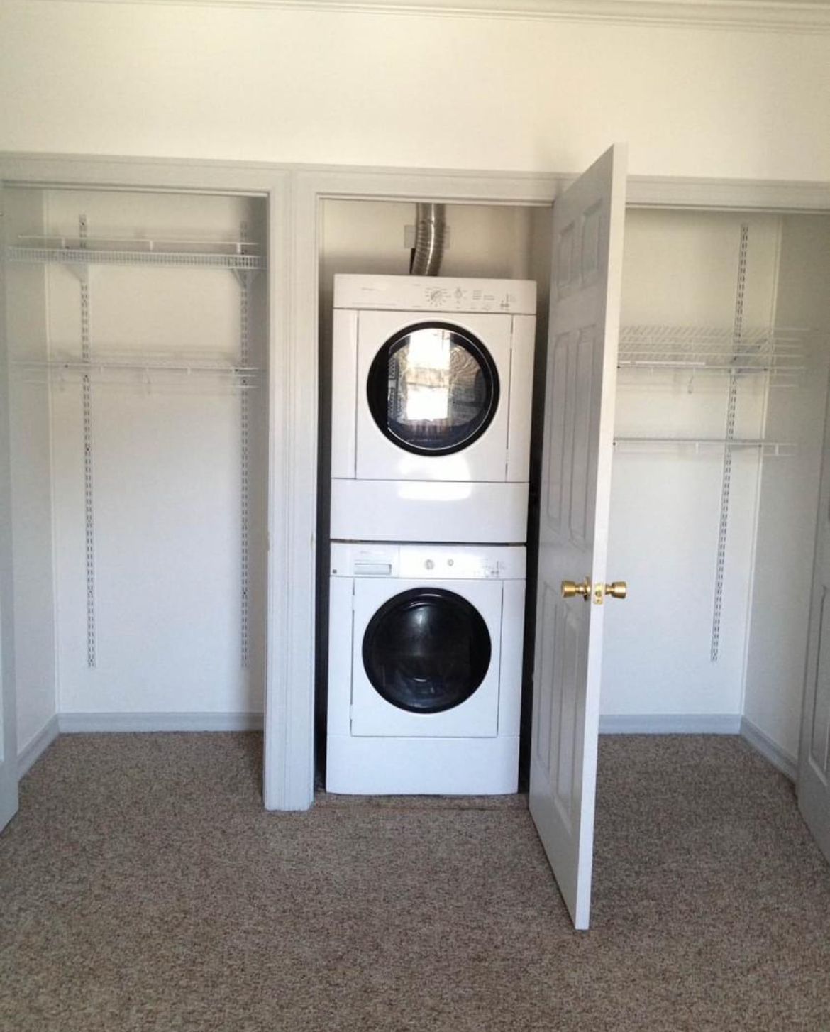 A washer and dryer are stacked on top of each other in a closet