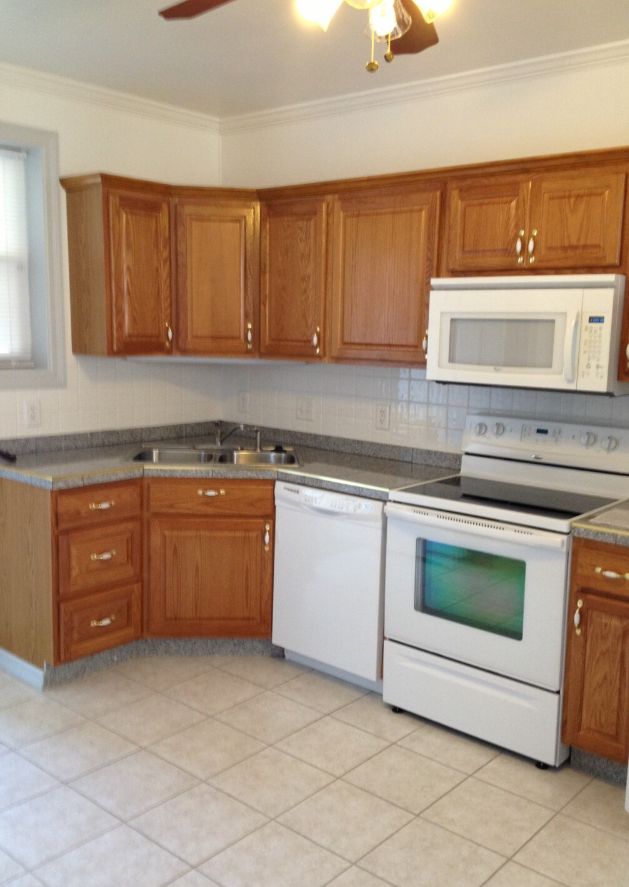A kitchen with wooden cabinets and white appliances