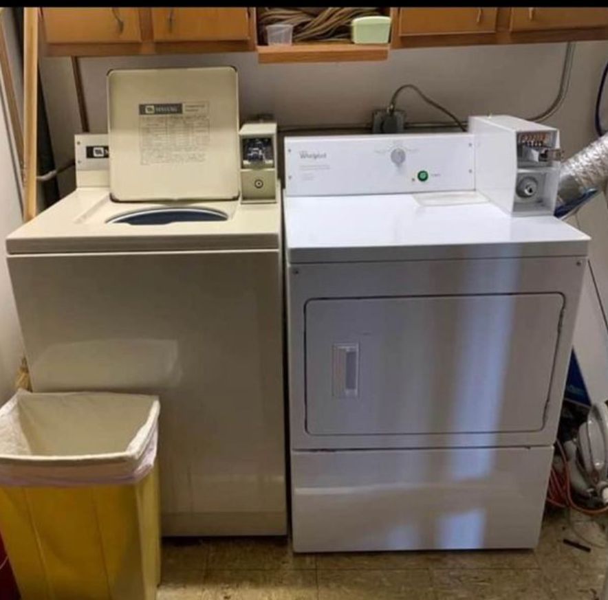 A washer and dryer are sitting next to each other in a laundry room.