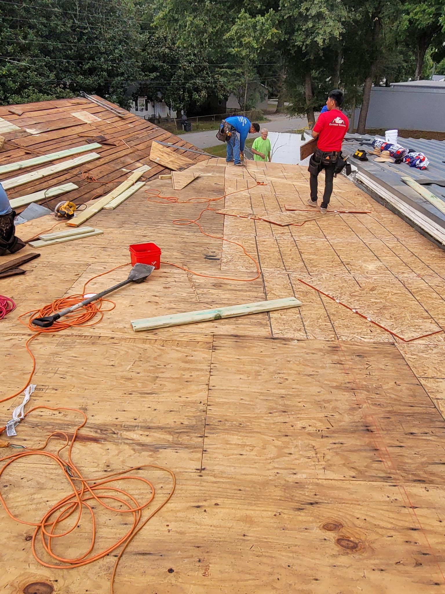 A group of men are working on a roof.