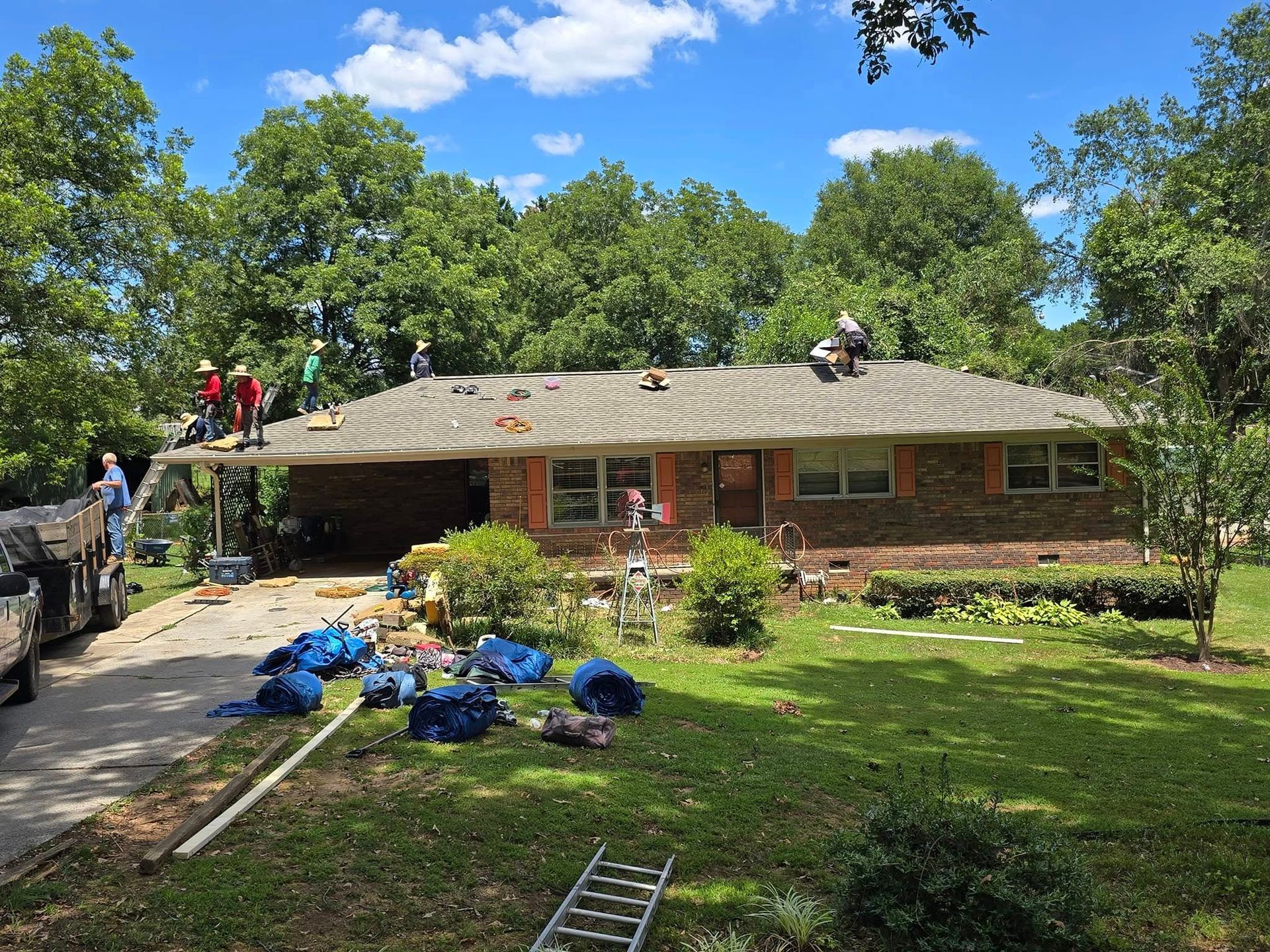 A group of people are working on the roof of a house.