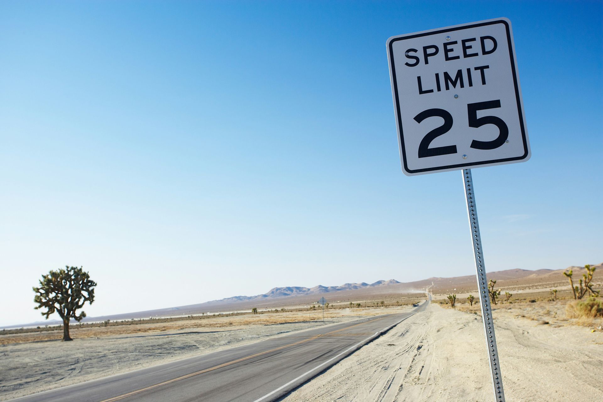 A speed limit sign on an empty desert road, symbolizing the limitations of traditional therapy approaches for trauma survivors.