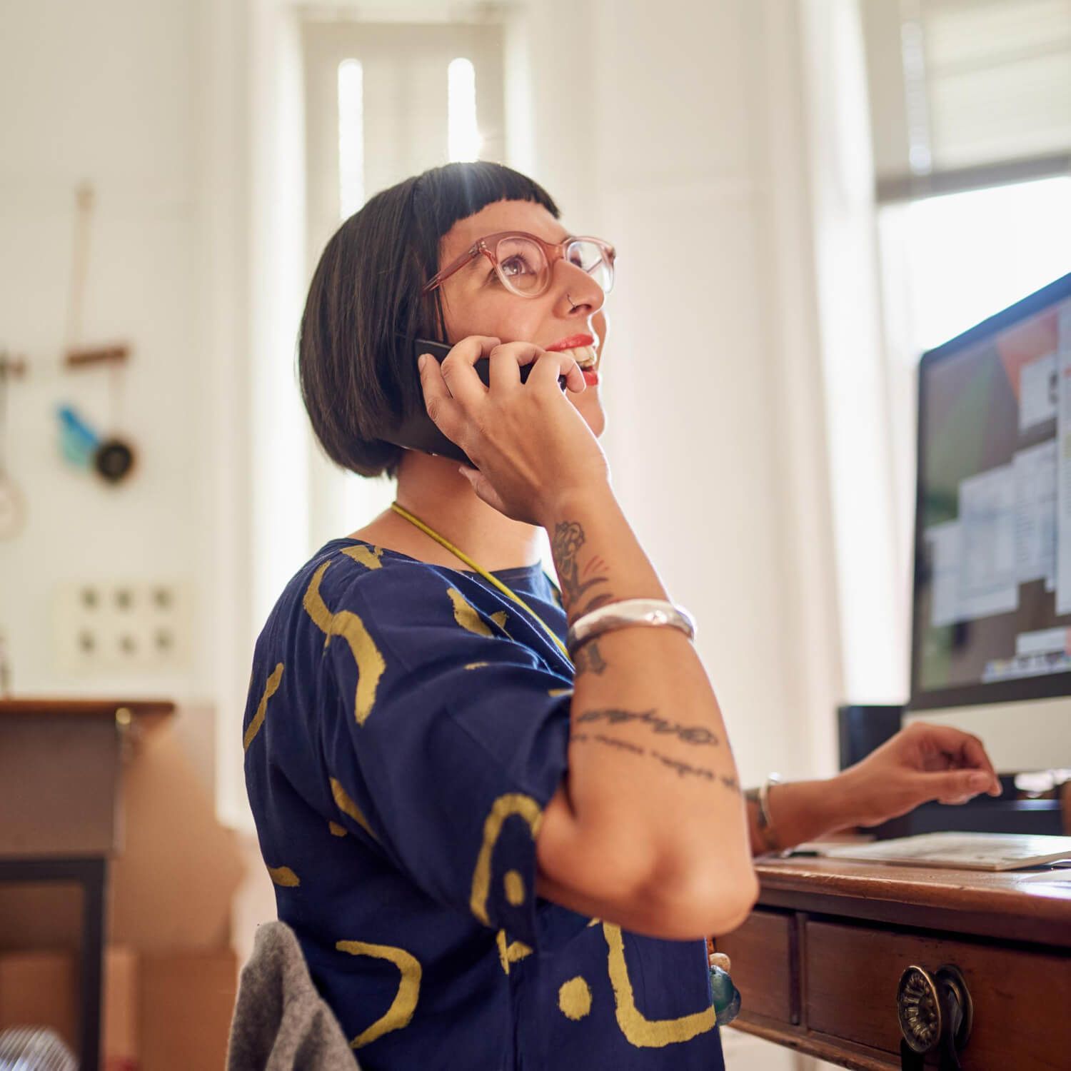 Professional woman on phone at desk representing someone seeking help for complex PTSD or scheduling trauma therapy consultation