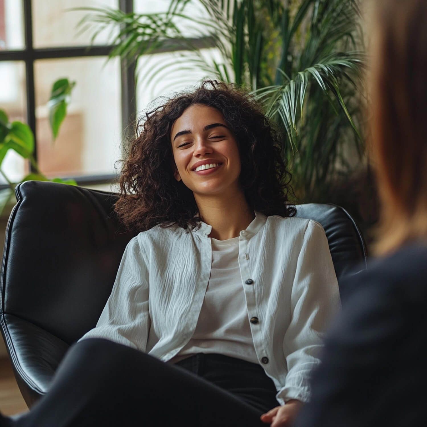 Smiling woman sitting comfortably representing hope and healing possible in complex PTSD recovery with proper treatment