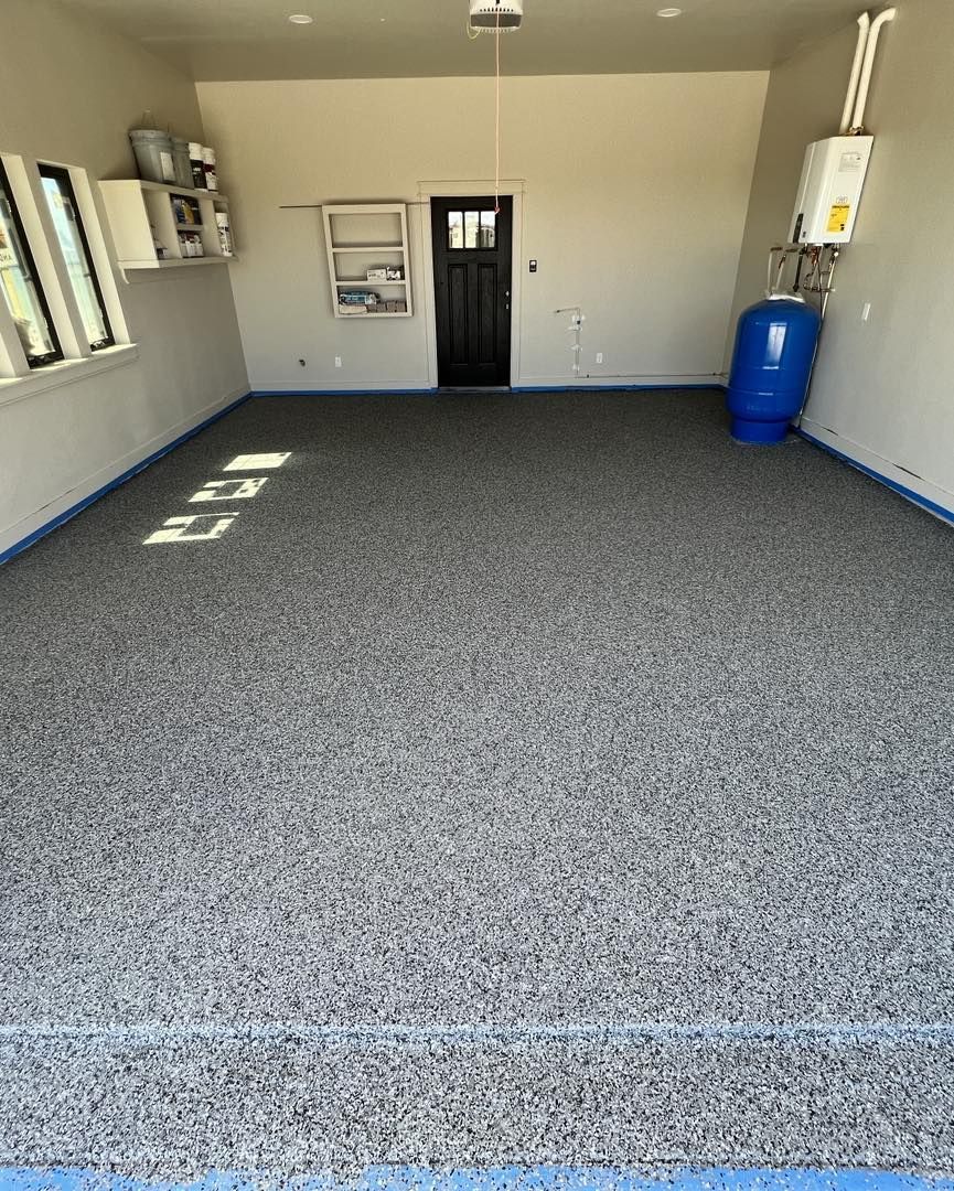 A garage with a gray floor and a black door.