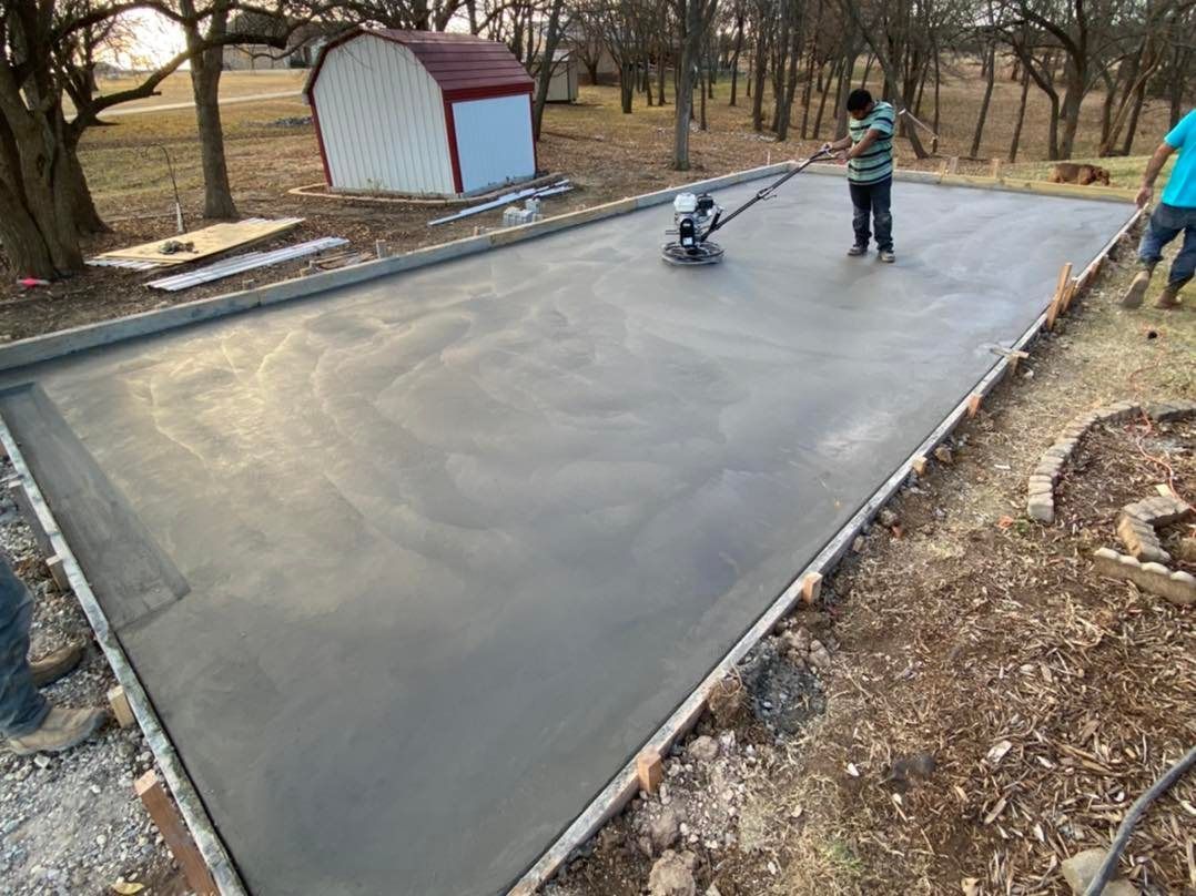 A man is using a machine to level a concrete driveway.