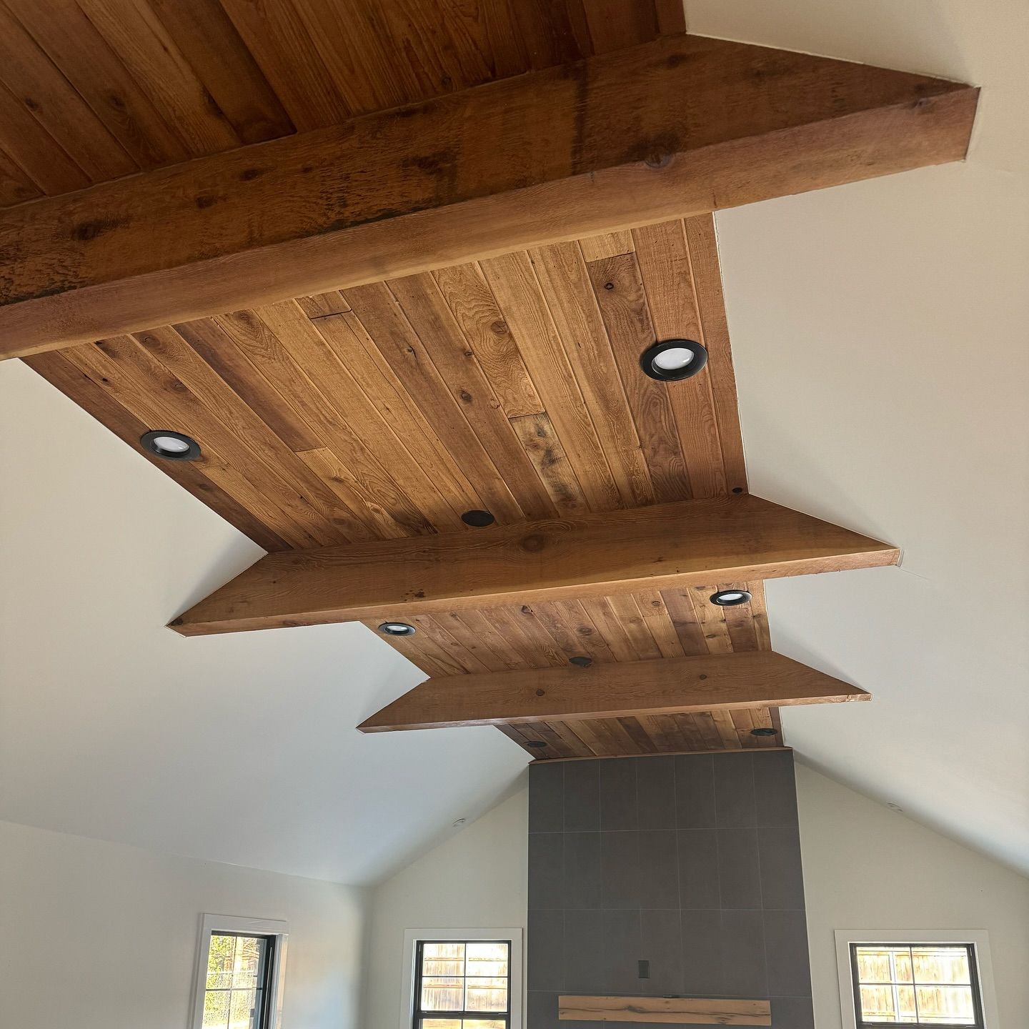 A room with a wooden ceiling and a fireplace