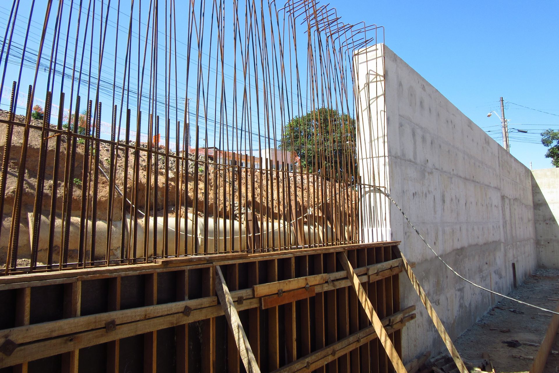A large concrete wall is being built in a construction site