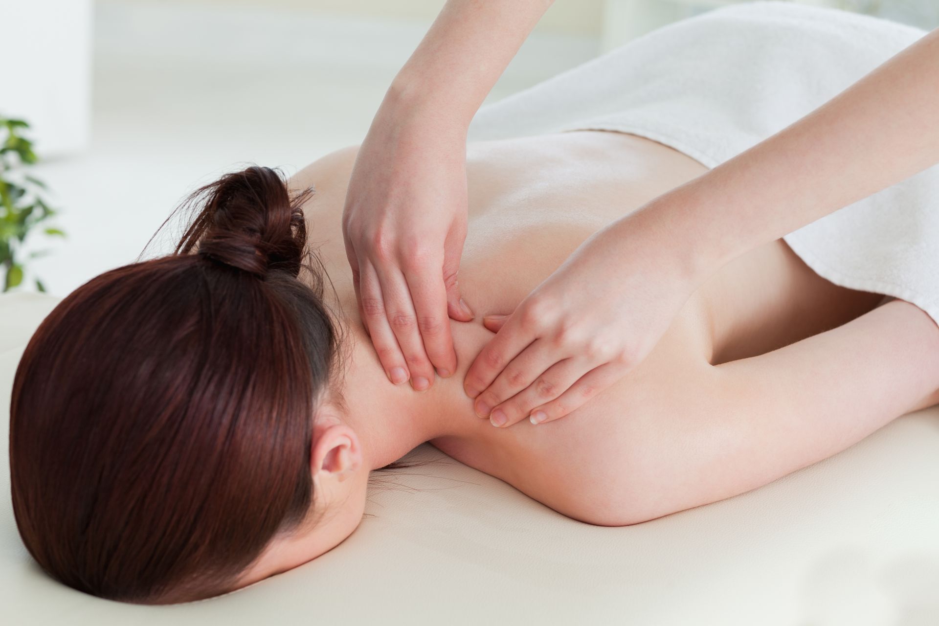 A woman is getting a massage on her back at a spa.