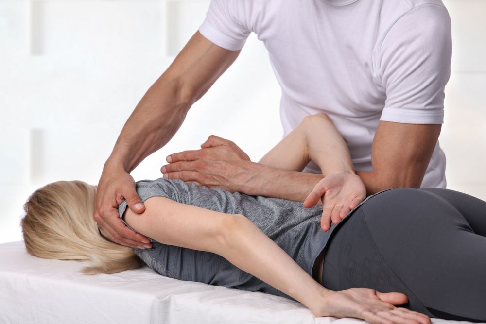 A man is giving a woman a massage on a table.