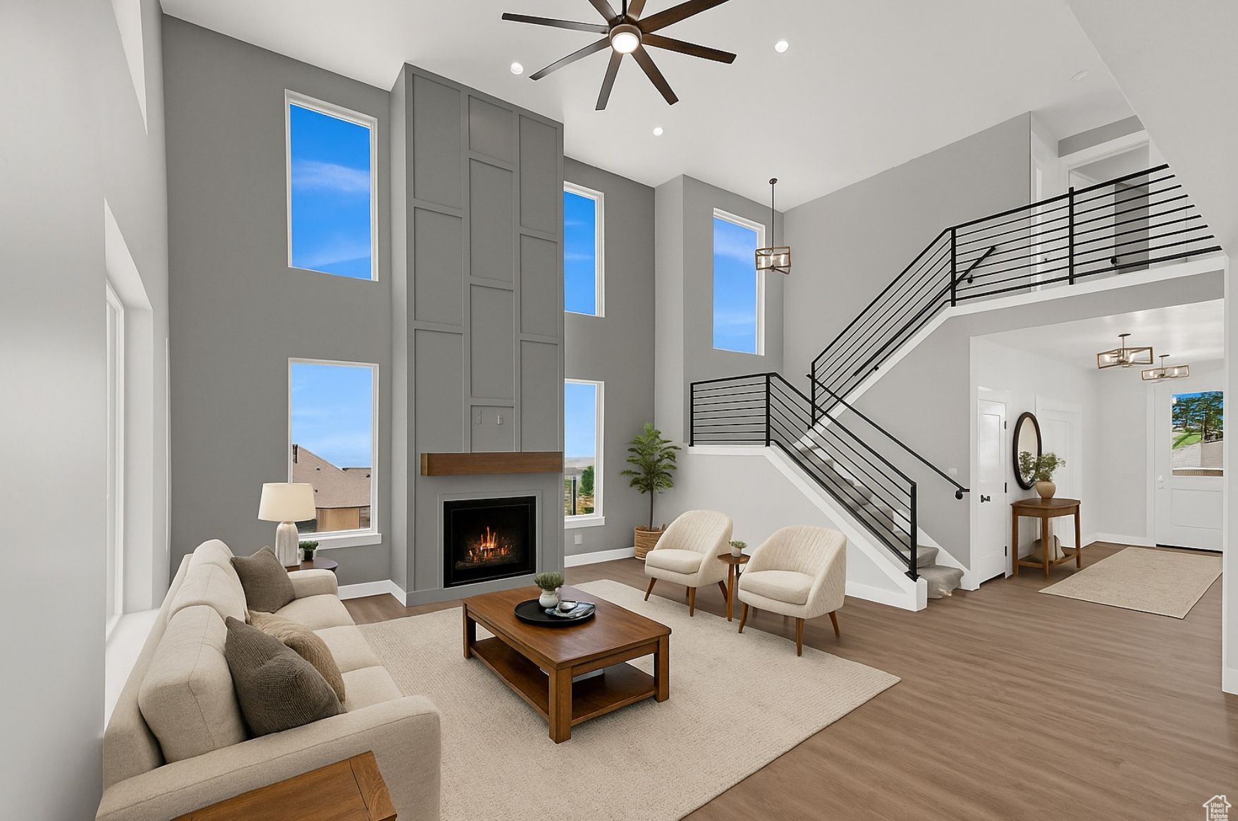 A dining room with a table and chairs and a wooden staircase.