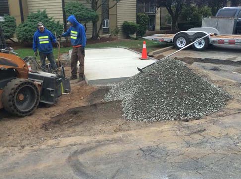 Concrete Dumpster Pad Before - Two Workers Repairing Concrete Dumpster in Kent, WA
