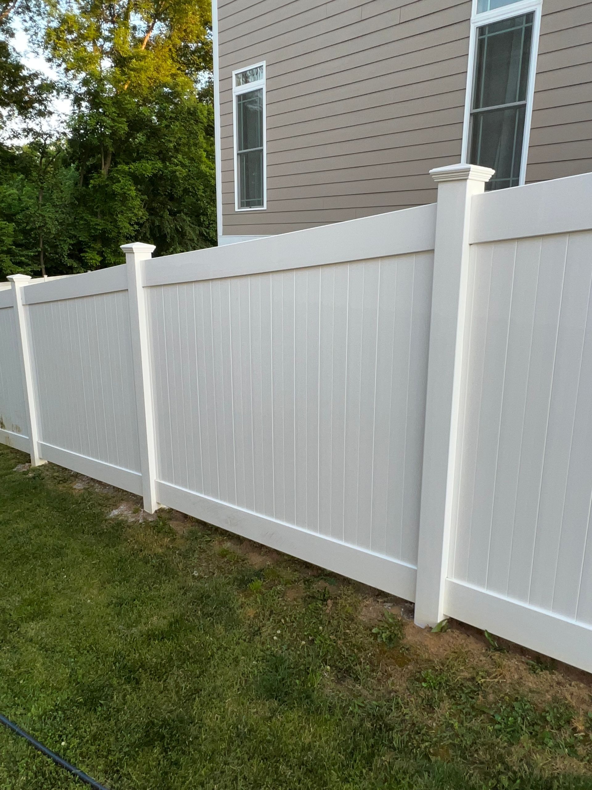 a white fence is sitting in front of a house .