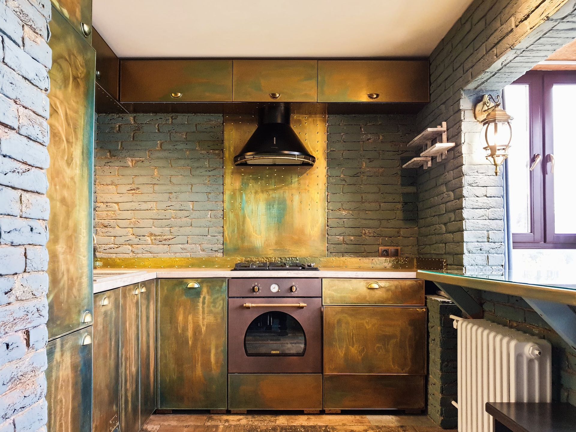 A kitchen with brass cabinets and a stove top oven