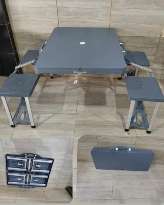 Mesa de picnic plegable gris con asientos adjuntos, que se muestra instalada y plegada dentro de un estuche de transporte.