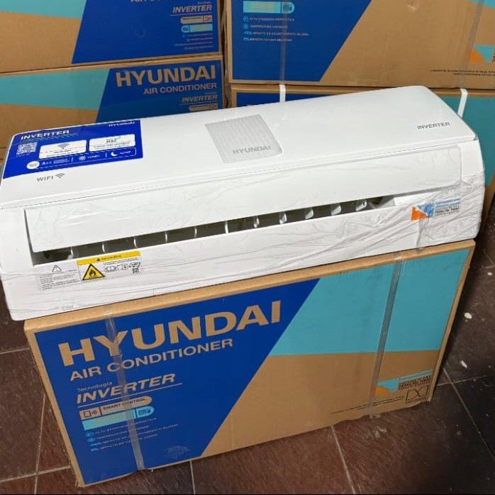 Aire acondicionado Hyundai de color blanco en su caja, rodeado de otras cajas.
