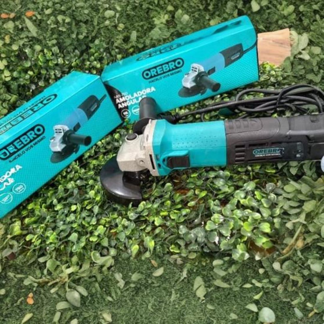 Amoladora angular y cajas con esquema de colores turquesa y negro sobre follaje verde.