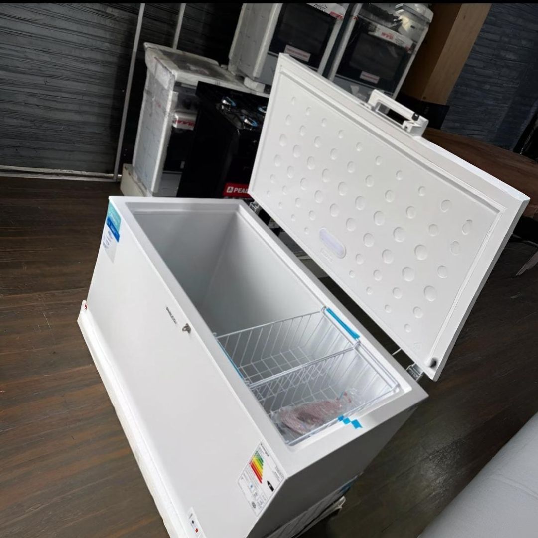 Congelador horizontal blanco con la tapa abierta, dejando al descubierto una cesta y el interior.