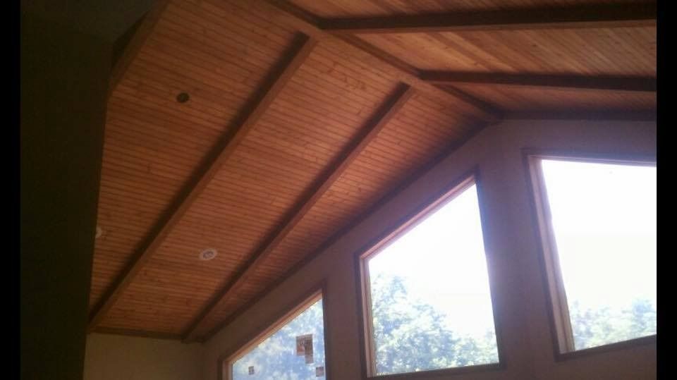 Wooden vaulted ceiling with triangular windows. Natural light streams in.