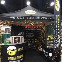 A booth at a convention with a tent and a sign that says `` we got you covered ''.