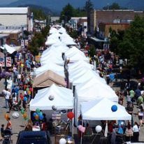 An aerial view of a street filled with tents and people at a festival.
