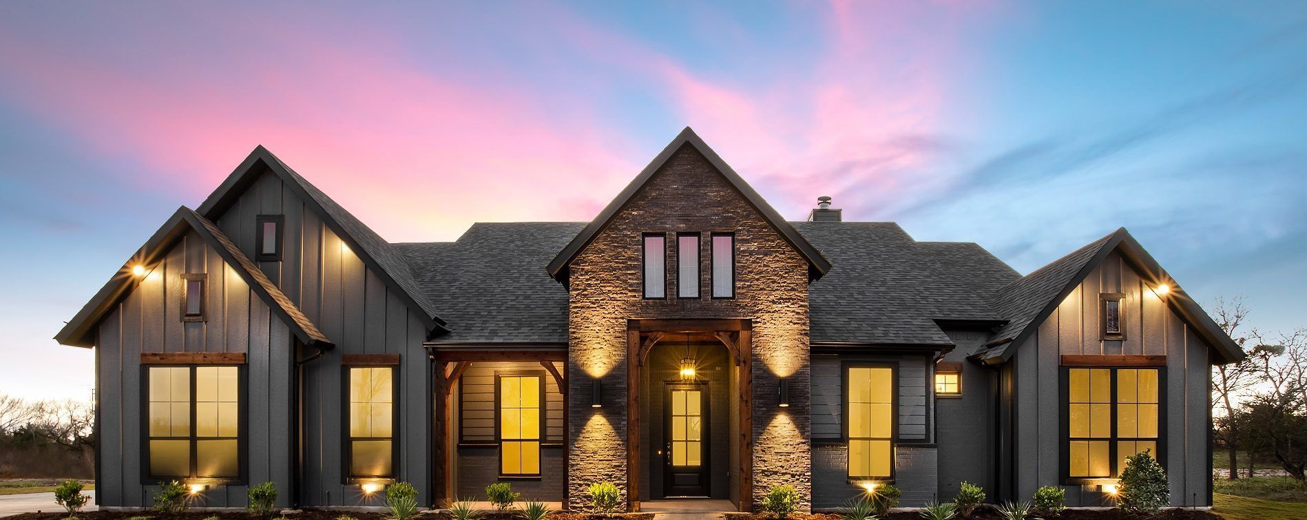 A large house with a lot of windows and a sunset in the background.