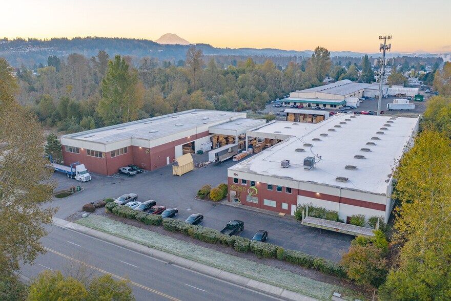 An aerial view of a large warehouse with a lot of cars parked in front of it.